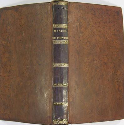 an old book with a brown cover sitting on top of a white table