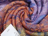 a close up of a multicolored scarf with a tag on it