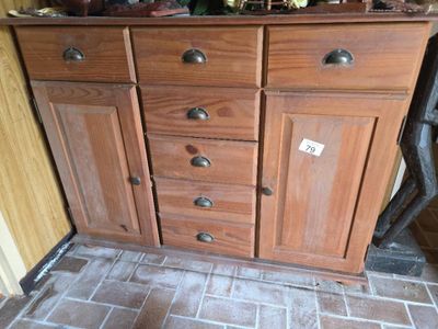 une armoire en bois comportant de nombreux tiroirs, surmontée d'autres tiroirs