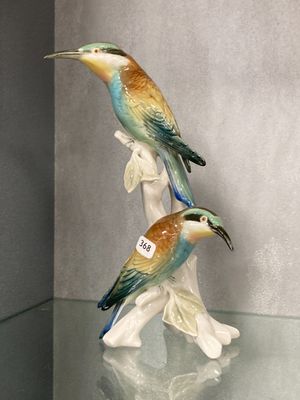deux figurines d'oiseaux posées sur une table en verre