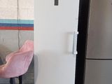 un réfrigérateur blanc et une chaise rose dans une cuisine