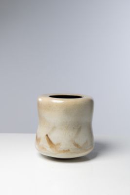 un petit vase blanc posé sur une table blanche