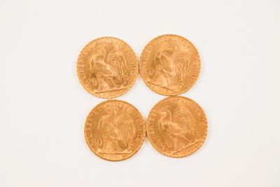 four gold sovereigns on a white surface with a white background