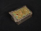 a small box with a design on it on a black surface