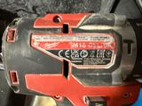 an image of a red and black corded drill is on a blue surface