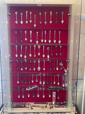 many spoons and spoon spoons on display in a glass case