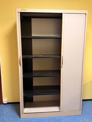 une armoire haute avec des étagères, placée dans un coin de la pièce