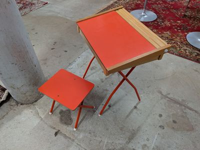 une table orange et deux chaises sur le trottoir