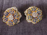 une paire de boucles d'oreilles en diamant bleu et blanc posées sur un tissu noir