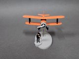 a small toy airplane with a man standing next to it
