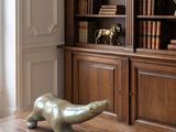 a statue of a bear on a table in front of a bookshelf