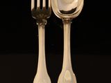 two spoons and a fork on a black table