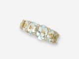 un gros plan d'une bague sertie de trois pierres sur fond blanc