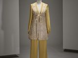 un mannequin vêtu d'une robe jaune et d'un pantalon jaune dans une pièce blanche