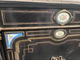 a black and gold chest of drawers with a clock on the top