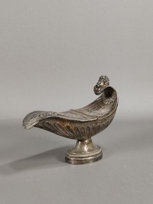 une image représentant un oiseau en métal argenté posé sur un socle