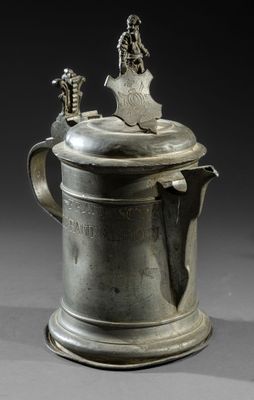an antique pewware with a bird on top of it