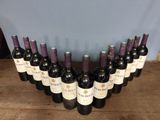 several bottles of wine are lined up on a wooden table