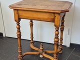 an old wooden table with a wooden top on a tiled floor
