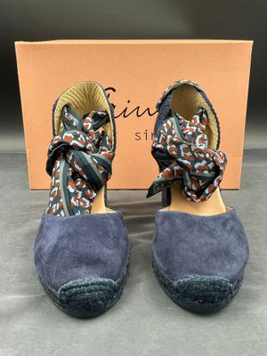 un gros plan sur une paire de chaussures avec une boîte en arrière-plan
