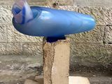 un objet bleu posé sur un bloc au sol