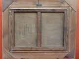 an old picture of a window with a wooden frame on a red wall