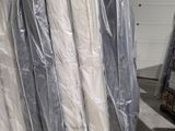 de nombreux matelas emballés dans du plastique dans un entrepôt