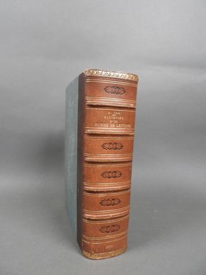an old book sitting on top of a table next to a gray background