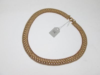gros plan d'un bracelet en chaîne en or sur une surface blanche