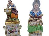two figurines of women sitting on top of each other