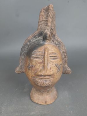une image représentant une sculpture en bois représentant une tête d'homme