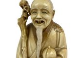statue of a smiling man holding a bird and holding a flower