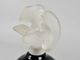 a black vase with a white flower on top of it