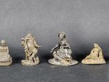 six silver figurines of people and a statue of a woman