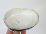 a person holding a small bowl with a tag on it