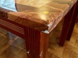 a wooden table with a glass top on a tiled floor