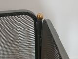 a close up view of a metal screen with a gold ball on it