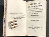 un livre ouvert sur lequel figure l'image d'un timbre