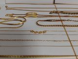 a lot of gold necklaces and bracelets on the counter