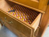 a wooden cabinet with a drawer that has a pencil inside of it