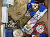 une boîte remplie de médailles et d'autres objets qui s'y trouvent