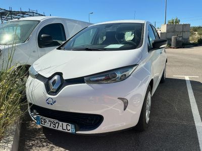 une voiture blanche garée sur un parking à côté d'une camionnette blanche