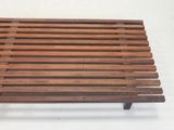 a wooden bench that is sitting on a white surface