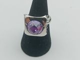 un gros plan d'une bague ornée d'une pierre violette montée sur un cône noir