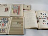 an open book sitting on top of a white table next to a pile of stamps