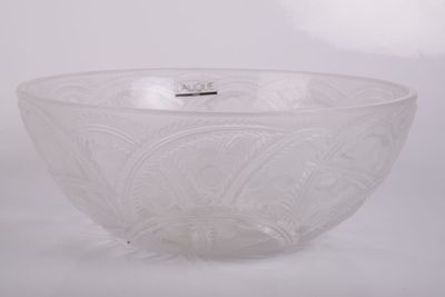 un saladier en verre transparent posé sur une surface blanche, muni d'une poignée argentée