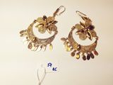 two pairs of gold toned earrings on a white surface