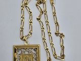 gros plan d'un collier en or sur une surface blanche