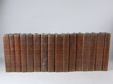 six old books stacked on top of each other on a white surface