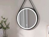 un miroir rond accroché au mur au-dessus d'une commode